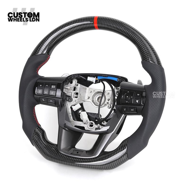 Toyota Custom Hilux Flat Bottom Steering Wheel – Carbon Fiber & Perforated Leather with Red Center Stripe | Fits 2021+ Hilux Models | Plug & Play | Premium Upgrade for Off-Road & Daily Driving | Made to Order | Performance Look & Feel
