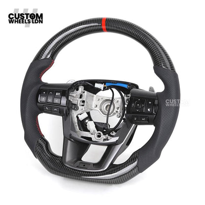 Toyota Custom Hilux Flat Bottom Steering Wheel – Carbon Fiber & Perforated Leather with Red Center Stripe | Fits 2021+ Hilux Models | Plug & Play | Premium Upgrade for Off-Road & Daily Driving | Made to Order | Performance Look & Feel