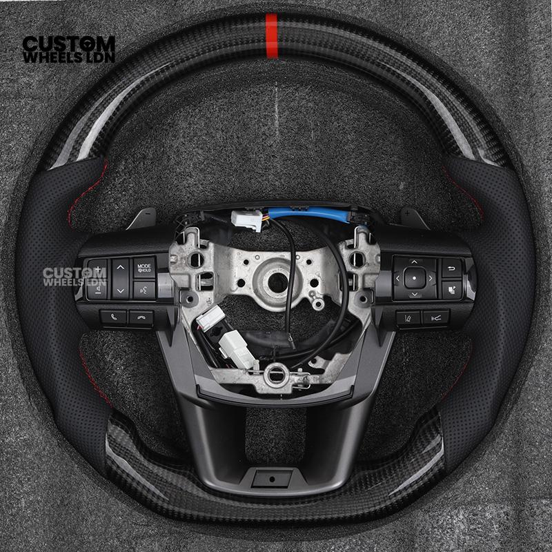 Toyota Custom Hilux Flat Bottom Steering Wheel – Carbon Fiber & Perforated Leather with Red Center Stripe | Fits 2021+ Hilux Models | Plug & Play | Premium Upgrade for Off-Road & Daily Driving | Made to Order | Performance Look & Feel