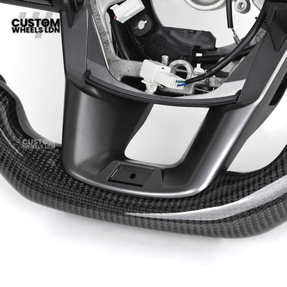 Toyota Custom Hilux Flat Bottom Steering Wheel – Carbon Fiber & Perforated Leather with Red Center Stripe | Fits 2021+ Hilux Models | Plug & Play | Premium Upgrade for Off-Road & Daily Driving | Made to Order | Performance Look & Feel
